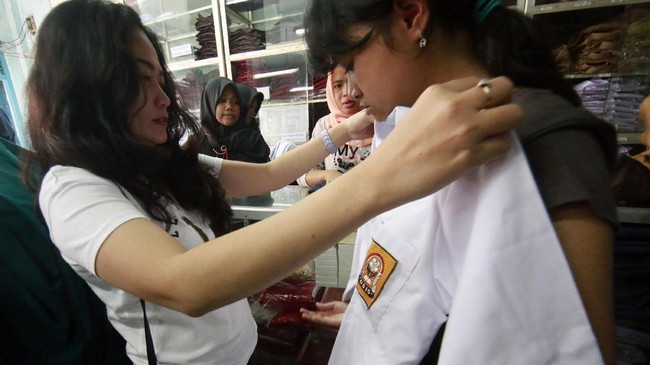 Calon pembeli mencoba baju seragam sekolah yang dijual di salah satu toko di Bandar Lampung, Lampung, Kamis (6/7). Memasuki tahun ajaran baru sejumlah toko penjualan perlengkapan sekolah mulai dipenuhi warga yang membeli berbagai perlengkapan sekolah. ANTARA FOTO/Ardiansyah/Spt/17.