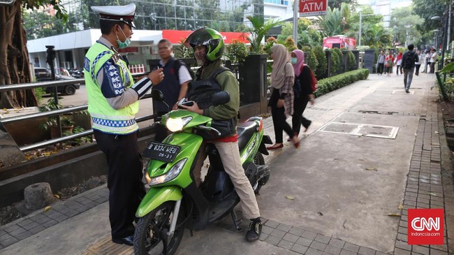 Polisi  menindak pengendara motor yang menggunakan trotoar di Jalan Kebon Sirih Jakarta Pusat, Senin, 17 Juli 2017. Minggu (16/7) lalu, para pemotor sempat bersitegang dengan Koalisi Pejalan Kaki, yang melakukan aksi damai di trotoar di Jalan Kebon Sirih, Jakarta Pusat. Dalam aksinya, Koalisi Pejalan Kaki memprotes hilangnya hak pejalan kaki untuk berjalan di trotoar dengan aman. Namun aksi tersebut mendapat reaksi keras dari sejumlah pemotor. CNNIndonesia/Safir Makki