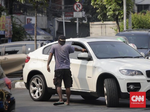 Polisi cepek atau dikenal dengan pak ogah mengatur lalu lintas di jalan samanhudi jakarta pusat