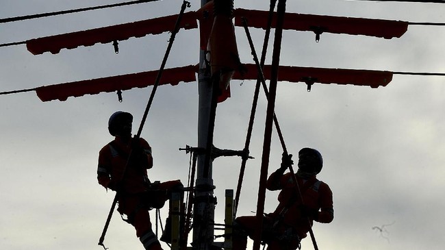 Sejumlah petugas PLN melakukan Pekerjaan Dalam Keadaan Bertegangan (PDKB) penggantian ikatan kabel A3CS di isolator yang 
