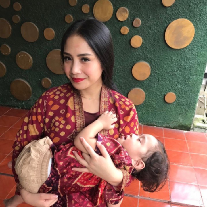 Motif baju yang dikenakan Nagita dan Rafathar kembar ya. Kelihatannya autentik banget. Sayang, Rafatharnya tidur waktu difoto. (Foto: Instagram @raffinagita1717)