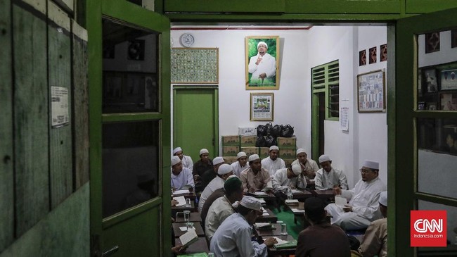 Posisi Rizieq Shihab kian diagungkan di kalangan Front Pembela Islam, walaupun kini terjerat pelbagai kasus hukum. Fotonya pun tersebar di gang-gang kecil.