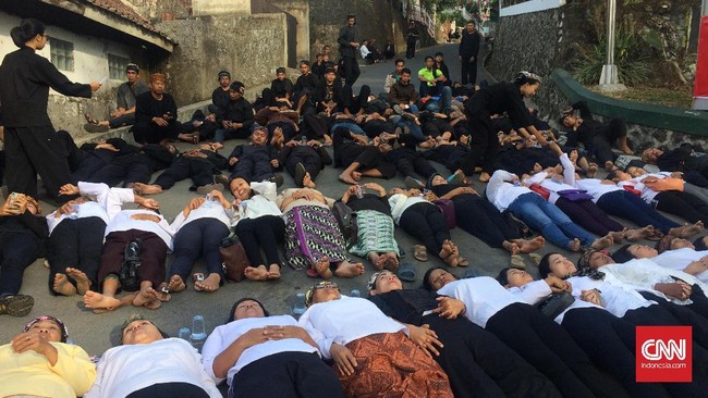 Puluhan warga masyarakat adat Sunda Wiwitan, Cigugur, Kuningan mulai berkumpul di depan jalan wilayah yang akan dieksekusi. Sebagian mereka terletang di jalan.