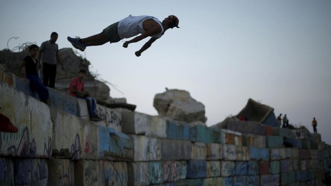 Para ahli parkour Palestina menggelar pertunjukan di perbatasan Gaza dan Israel, dekat lokasi protes massal dan bentrokan yang memakan korban puluhan jiwa.