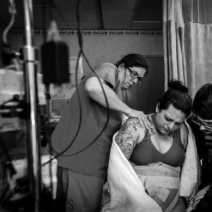 Wah, dedikasinya tinggi banget ya, Bun. Perawat ini sampai ikut memijat punggung ibu yang akan melahirkan demi membuatnya lebih nyaman.(Foto: Katie Lacer MommaKTShoots)