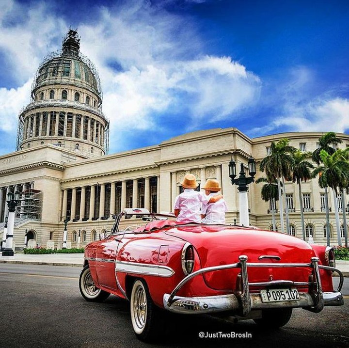 <p>Duduk di atas mobil terbuka di depan El Capitolio, Cuba. (Foto: Instagram @justtwobrosin)</p>