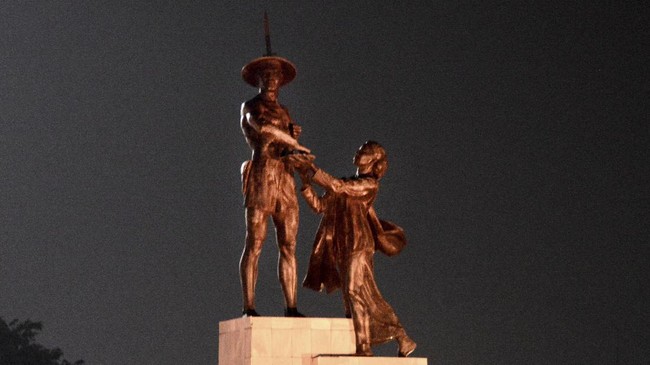 Patung Tugu Tani dipersoalkan karena dianggap simbol komunisme, padahal hal itu terkait pembebasan Irian Barat. Besok, apel anti-PKI berlangsung di kawasan itu.