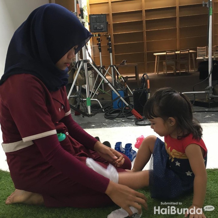 <p>Mau main di playground, Gempi pakai kaus kaki dulu dibantuin sama Koneng ya.</p>