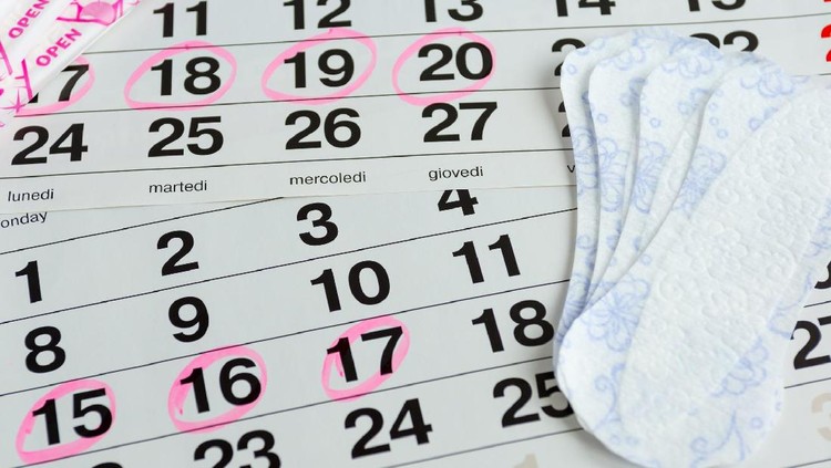 Woman protecting health , menstruation days , laying on a calendar with the selected days