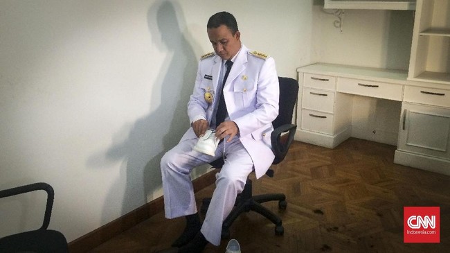 Anies Baswedan dan Sandiaga Uno mencoba busana dinas Pemprov DKI. Masing-masing dari mereka mengusung gaya khas selama sesi pemotretan.