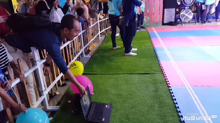Ayah ini menggunakan jurus menyodorkan laptop agar si kecil semangat dalam lomba merangkak.