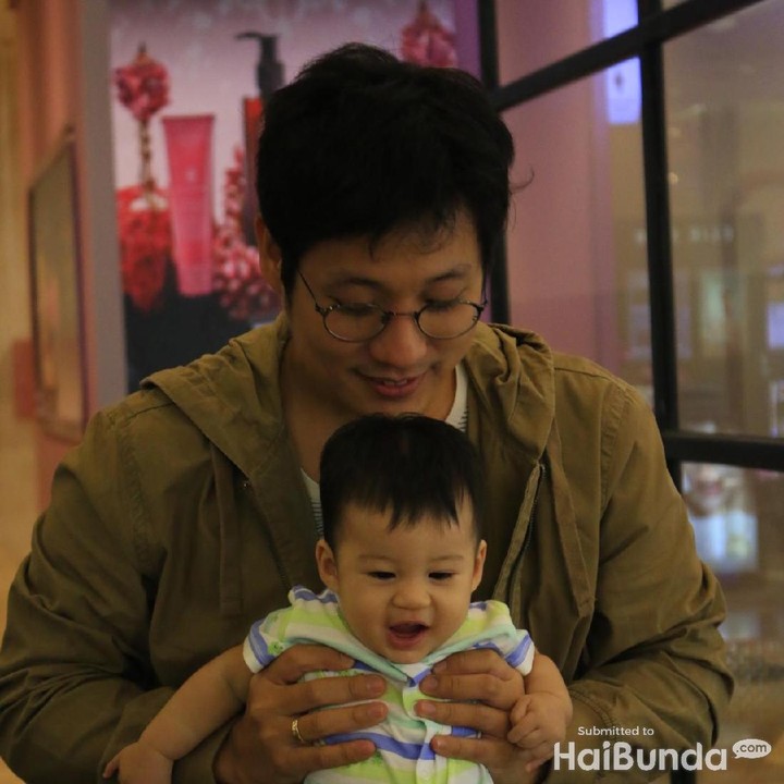 <p>Dipangku Ayah Junior, Iori juga tetap tersenyum. </p>