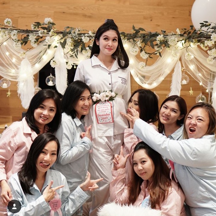 <p>Nuansa putih dipilih dalam baby shower ini. Tuh lihat, banyak bunga warna putihnya juga. (Foto: Instagram @sandradewi88)</p>