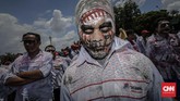 FOTO: Unjuk Rasa Buruh Awak Mobil Tangki Pertamina Demo disertai aksi teatrikal menggendong pocong di jalan raya, menggeliat dan meringkuk sebagai simbol matinya kesejahteraan buruh Pertamina.