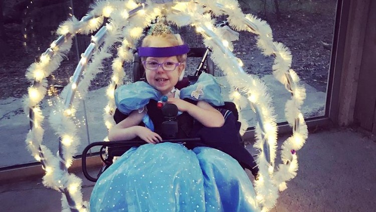 Sang bunda mengutak-atik kursi rodanya sehingga gadis cilik ini bisa jadi Cinderella di pesta Halloween.