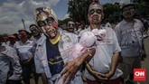FOTO: Unjuk Rasa Buruh Awak Mobil Tangki Pertamina Demo disertai aksi teatrikal menggendong pocong di jalan raya, menggeliat dan meringkuk sebagai simbol matinya kesejahteraan buruh Pertamina.