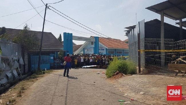 Area di sekeliling pabrik kembang api yang terbakar di Kosambi, Kabupaten Tangerang dikelilingi warga yang penasaran. Mereka bertumpuk di belakang garis polisi.