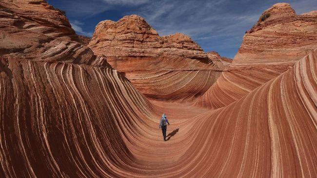 Hikers walk amongst the unique U-shaped troughs of 'The Wave' rock formation at the Coyotes Buttes North wilderness area near Page, Arizona on October 30, 2017.
The Wave is a sandstone rock formation in northern Arizona and was formed by a combination of water and wind erosion and due to its fragile nature, access is limited to only 20 hikers per day. / AFP PHOTO / Mark Ralston