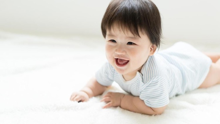 Asian Baby crawling on the bed.