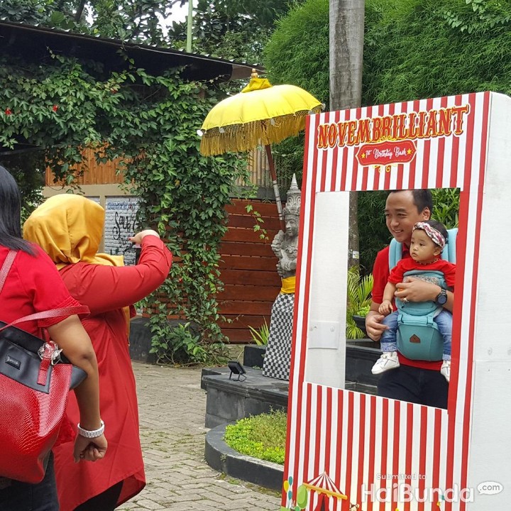 <p>Ayah pose sambil gendong si kecil yang cantik.</p>