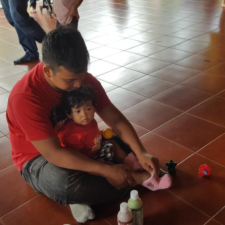 <p>Terampil juga nih, memakaikan sepatu buat si kecil.</p>