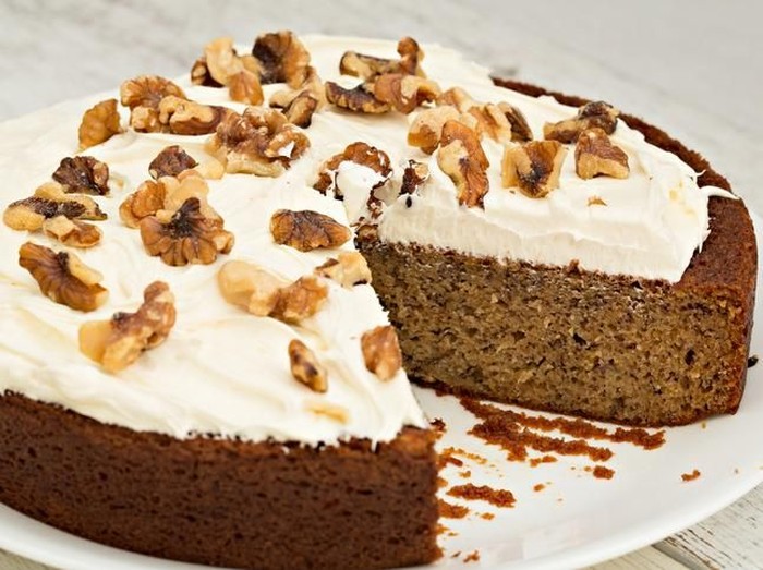 A high angle close up shot of a freshly baked banana cake with one slice gone.