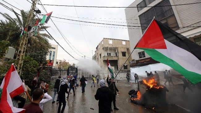 Ratusan demonstran anti-Trump bentrok dengan aparat keamanan Lebanon di luar Kedutaan Besar AS di Beirut, Minggu (10/12).