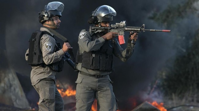 Israeli security forces take position during clashes with Palestinian protestors in the West Bank town of Tulkarem, following a demonstration against US President Donald Trump's decision to recognise Jerusalem as the capital of Israel, on December 11, 2017.  / AFP PHOTO / JAAFAR ASHTIYEH