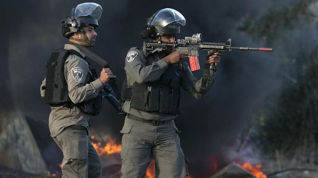 Israeli security forces take position during clashes with Palestinian protestors in the West Bank town of Tulkarem, following a demonstration against US President Donald Trump's decision to recognise Jerusalem as the capital of Israel, on December 11, 2017. / AFP PHOTO / JAAFAR ASHTIYEH