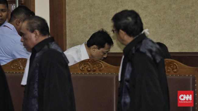 Mengenakan kerudung warna putih dan baju warna hitam, Deisti yang duduk di kursi pengunjung terus menundukkan kepala dan menangis.