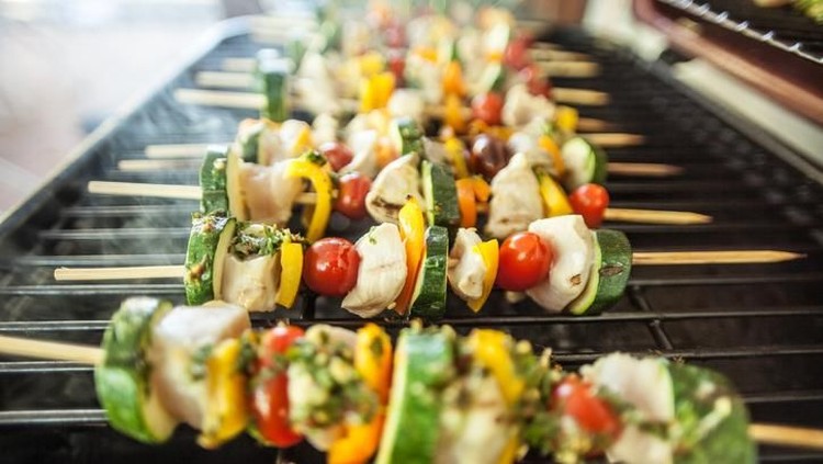 alat panggang Tasty Kebabs Shishkabobs on Grill with wood skewers, and a medley of food being grilled to perfection in a shallow depth of focus look. Chicken, pepper, onions, glaze and squash.