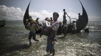 A Bangladeshi man helps Rohingya Muslim refugees to disembark from a boat on the Bangladeshi shoreline of the Naf river after crossing the border from Myanmar in Teknaf on September 30, 2017.
More than 2,000 Rohingya have massed along Myanmar's coast this week after trekking from inland villages in Rakhine state to join the refugee exodus to Bangladesh, state media reported September 30. They follow more than half a million fellow Rohingya who have emptied out of northern Rakhine in a single month, fleeing an army crackdown and communal violence the UN says amounts to 