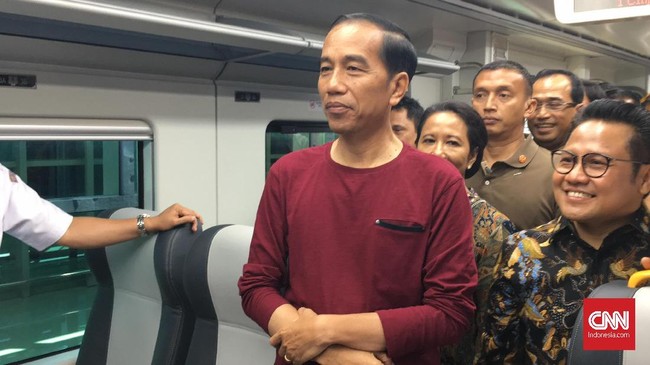 Jokowi berpenampilan santai saat meresmikan pengoperasian kereta bandara yakni mengenakan kaus dan celana jin. Sementara para menteri berpakaian resmi.