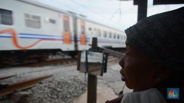 Ibu Sri Wiyani (60) seorang penjaga pintu kereta api saat ditemui di kawasan Klender, Jakarta Timur, Kamis (4/1/2018). Pintu perlintasan yang terbuat dari bambu itu dijaga Ibu Sri sejak tahun 1983.