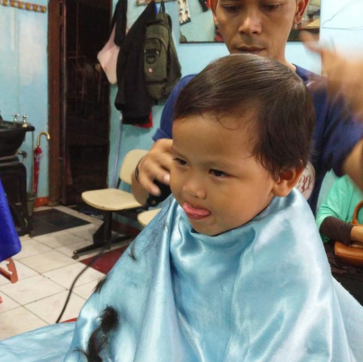 Kalau yang ini potong rambut sambil menjulurkan lidah. Duh lucu banget sih, Nak. (Foto: Instagram @ferypus)
