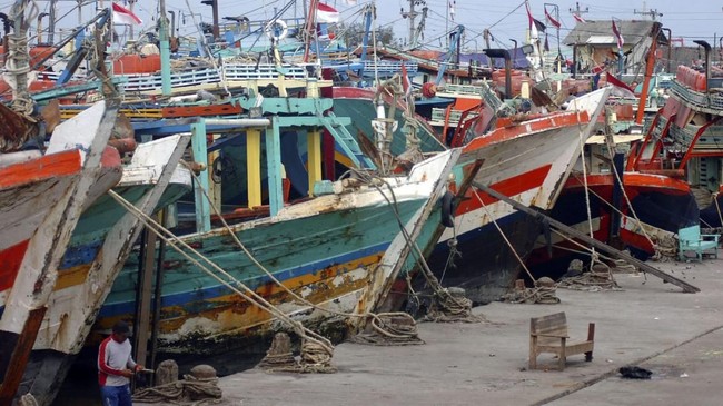 Nelayan berada di samping kapal cantrang saat tidak melaut di Pelabuhan Jongor, Tegal, Jawa Tengah, Minggu (31/12). Larangan alat tangkap cantrang mulai 1 Januari 2018 oleh Kementerian Kelautan dan Perikanan (KKP), membuat ratusan kapal di daerah tersebut tidak melaut dan diharuskan mengganti alat tangkap. ANTARA FOTO/Oky Lukmansyah/aww/17.