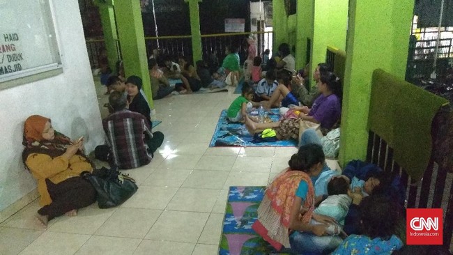 Sadiah dan Andi berenang menembus banjir setinggi sekitar dua meter seraya menggendong dua putra mereka untuk mengungsi di Pejaten Timur, Senin (5/2) malam.