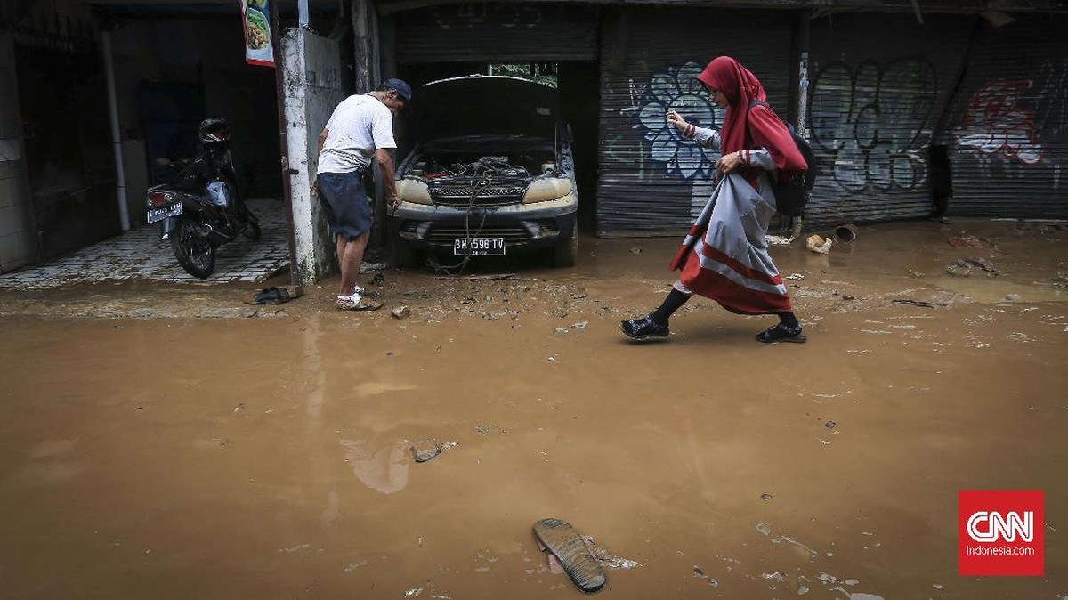FOTO: Banjir Surut, Warga Bersih-bersih Menguras Lumpur