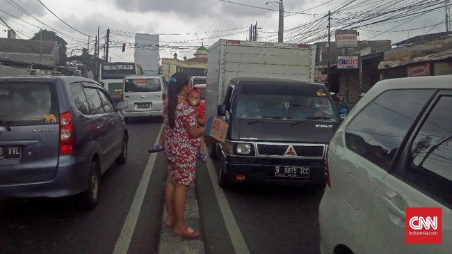 Usai banjir luapan kali Ciliwung yang melanda permukimannya kemarin, hari ini warga Cililitan Kecil, Jakarta Timur meminta bantuan di jalan raya.