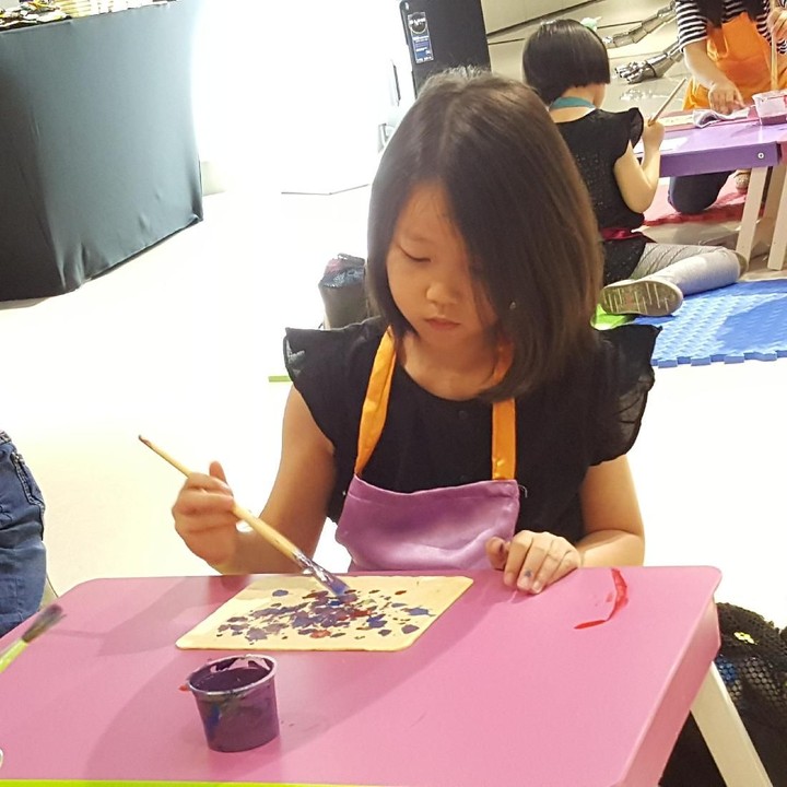<p>Sebelum melukis dengan media kaleng, anak-anak pemanasan dulu dengan melukis di atas kertas. Hmm, gadis kecil ini sedang melukis apa ya?</p>