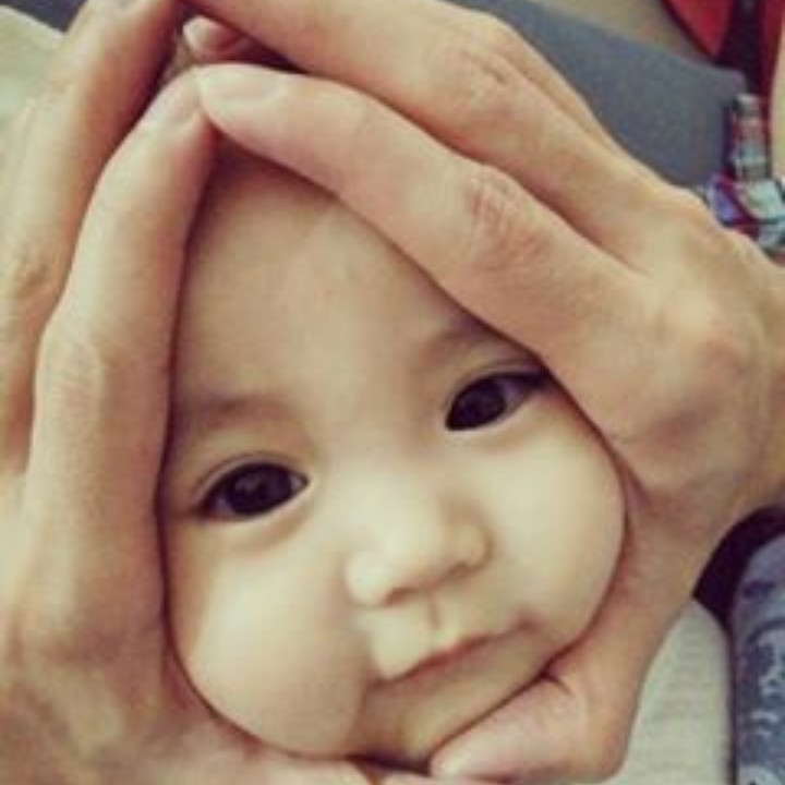 <p>Hal terpenting dalam melakukan pose onigiri baby adalah tidak mencengkeram erat wajah bayi. Hiks, kasihan, nanti bayinya nggak nyaman. Ya, tangan kita cuma membingkai lembut wajahnya dengan posisi jari-jari tangan membentuk segitiga menyerupai onigiri. (Foto: Instagram @jillyteh)</p>