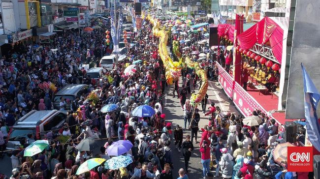 Pengunjung Pawai Naga meringsek ke arah rangkaian, dengan harapan mendapatkan sisik atau jenggot naga, yang dipercaya dapat membawa berkah.