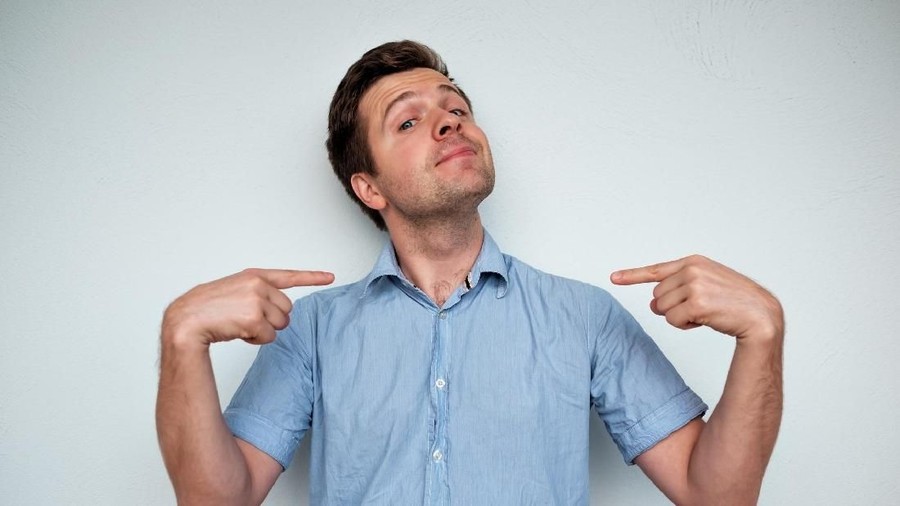 Sombong Self-satisfied and proud caucasian young man looks forward showing with index fingers on himself. congkak, angkuh.