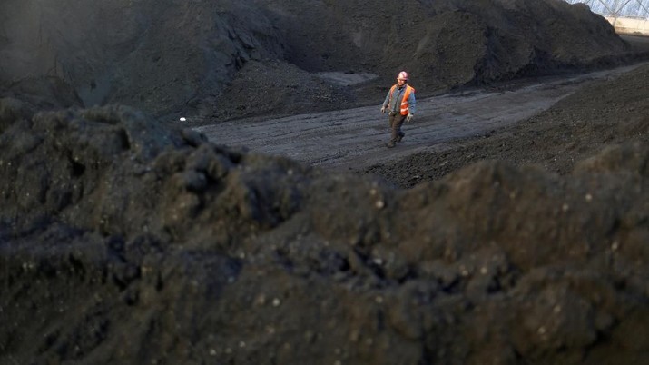 FILE PHOTO: A worker walks past coal piles at a coal coking plant in Yuncheng, Shanxi province, China January 31, 2018. Picture taken January 31, 2018.  REUTERS/William Hong/File Photo