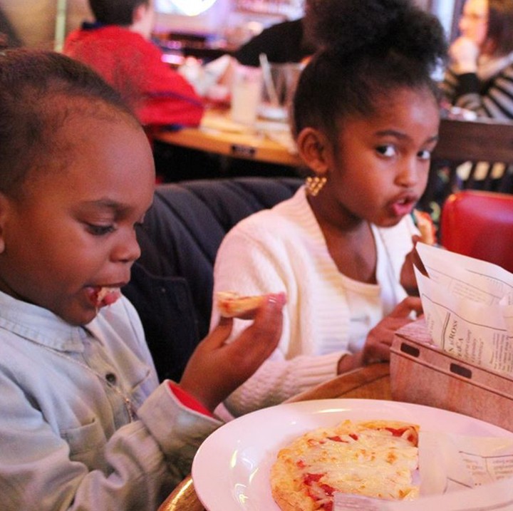 <p>Yang satu lagi serius memperhatikan pizza-nya, yang satu melirik. Ada-ada aja tingkah dua anak ini. (Foto: Instagram/ @sannabrooks)</p>