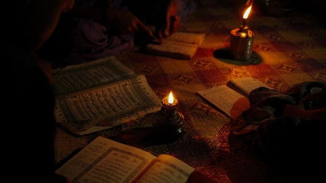 ACEH, INDONESIA - 02 APRIL : Anak-anak warga Desa Tampor Paloh, Kecamatan Simpang Jernih, Kabupaten Aceh Timur, Aceh, Indonesia mengaji dibantun dengan alat penerangan lampu teplok, pada Jumat 30 Maret 2018. Empat desa di Kecamatan Simpang Jernih, belum memiliki saluran arus listrik dari Perusahaan Listrik Negara (PLN) sejak kecamatan itu beridiri pada 1919. ( Khalis Surry - Anadolu Agency )