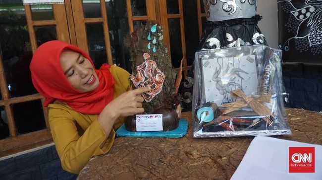 Enie Mu'alifah berkreasi dengan bahan bekas dan plastik bekas untuk membuat berbagai kostum dan benda seni yang menarik.