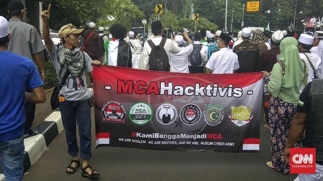 Spanduk Muslim Cyber Army dibentangkan dua orang peserta Aksi 64. Spanduk itu bertuliskan 'Kami Bangga Menjadi MCA'.