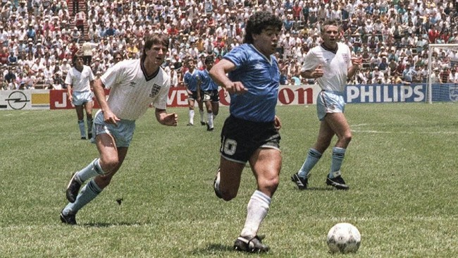 Argentinian forward Diego Armando Maradona runs past English defenders Terry Butcher (L) and Terry Fenwick (2nd L) on his way to scoring his second goal during the World Cup quarterfinal soccer match between Argentina and England 22 June 1986 in Mexico City.  Argentina advanced to the semifinals with a 2-1 victory.  AFP PHOTO / AFP PHOTO / STAFF
