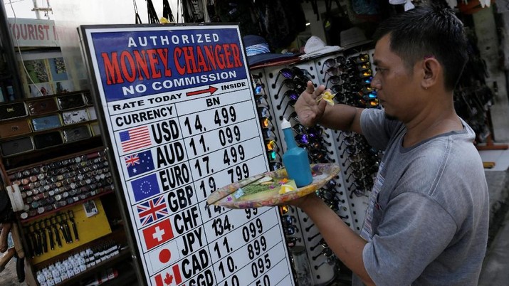 A Balinese man makes a Hindu offering outside a shop which offers currency exchange services in Kuta, on the resort island of Bali, Indonesia  April 30, 2018. REUTERS/Johannes P. Christo